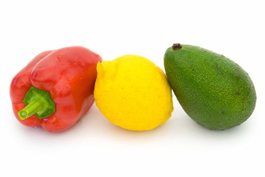 Red sweet pepper, yellow lemon and green avocado on a white background