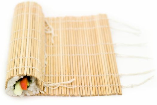 Cooking sushi. Bamboo rug on a white background