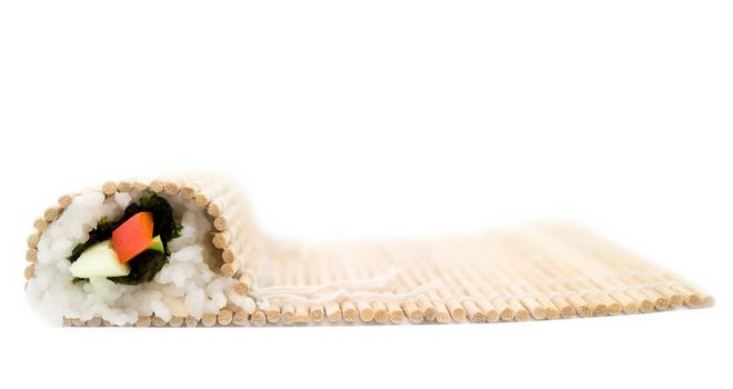 Cooking sushi. Bamboo rug on a white background