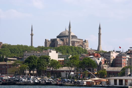 Antique mosque with four minarets over blue sky