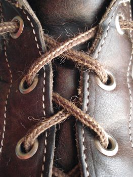 The uppers of a leather hiking boot have a worn and comfortable look to them.