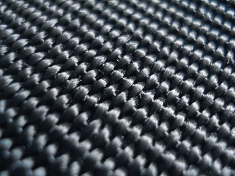Black fabric reveals an intricate pattern of ridges up close.
