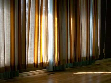 Warm filtered sunlight through classic curtains.