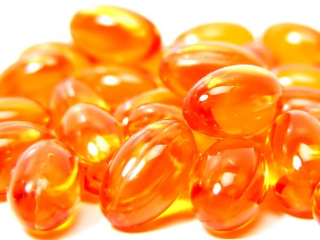 Orange vitamin capsules macro on a white background