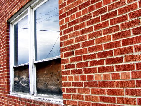 Weathered window on the side of an aging brick building.