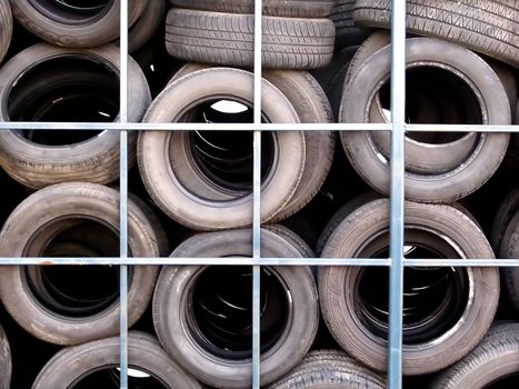 A pattern of old used tires behind a tire shop