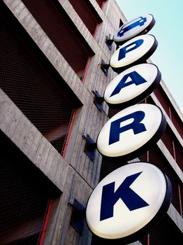 Lit parking structure sign directing you into the lot.