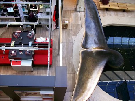 Portion of a metal whale fountain in world famous shopping mall.