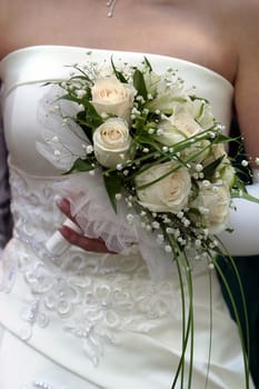 The bride holds a wedding bouquet