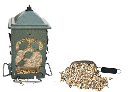 garden bird feeder filled with seeds with a scoop of seeds on the side. Isolated against a white background.