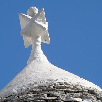 pinacle on roof of trullo house in Apulia regionin Italy. Trulli are local,traditional Apulian stone dwelling with a conical roof.
They may be found in the towns of Alberobello, Locorotondo, Fasano, Cisternino, Martina Franca and Ceglie Messapica.