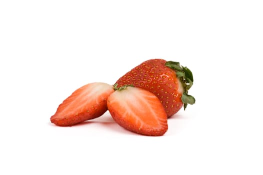 two strawberries, one cut in half, isolated