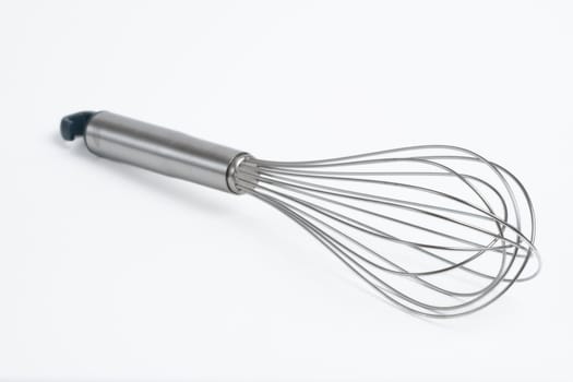 stainless steel whisk, shallow DOF, on white