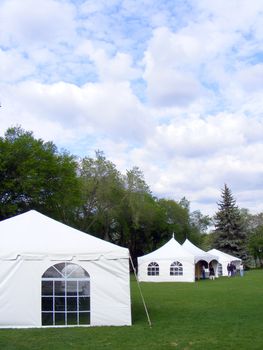 White tents setup in a public park for a celebration.