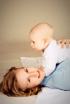 happy young beautiful mother with her little baby on the floor