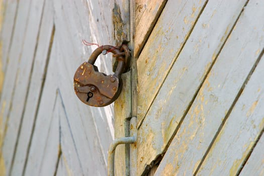 The old rusty lock on a wooden gate