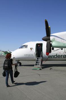Passenger embarking on a Widerøe flight at Alta airport, Finnmark, Norway.  