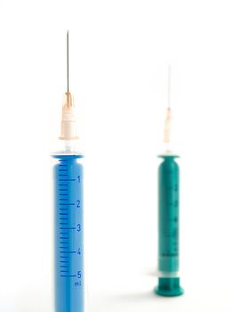 two syringes against clear white background taken from up close