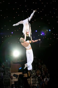 Two air acrobats carry out exercise on a circus ring