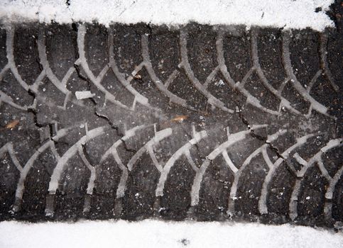 Print auto tire on asphalt on wet snow