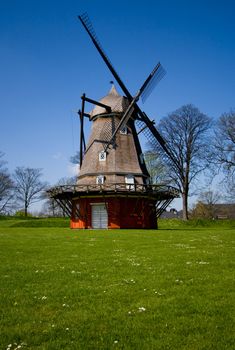 Old mill in a green meadow on summer day