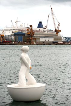 White buoy shaped like a man in Port Vell. Barcelona