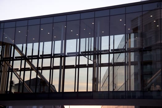 A beautiful glass bridge between shopping malls. The picture is taken in the late evening.