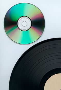 Close up of a cd and partial record over white background