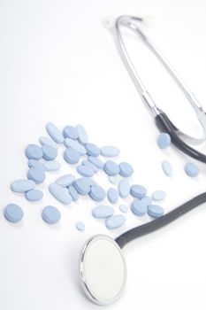 Medicines and stethoscope on white background, close-up