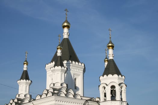 White church with vlack roof and blue sky