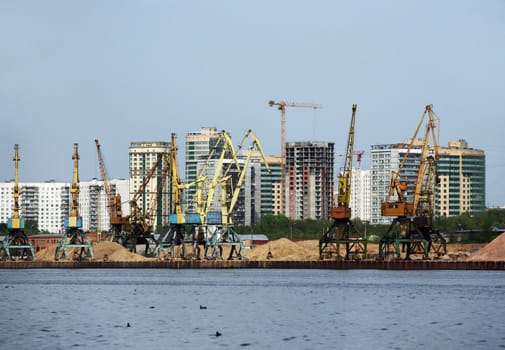 Machines on development of sand on a background of  buildings