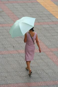 Chinese girl walking in the street of Xi'an with her umbrella