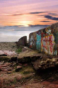 graffiti on a sea break at sunset