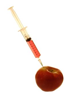 syringe with red fluid injectig a red apple
