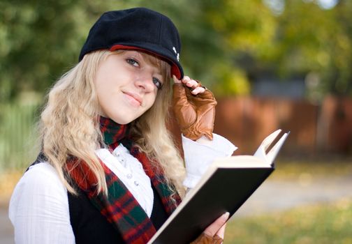 Student girl studying outside in the autumn