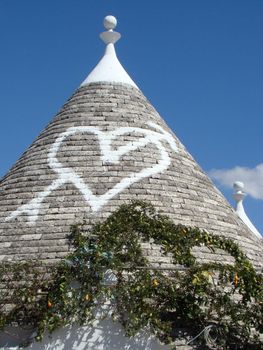 conical roof of trullo house in Apulia, region in Italy. Trulli are local,traditional Apulian stone dwelling with a conical roof. They may be found in the towns of Alberobello, Locorotondo, Fasano, Cisternino, Martina Franca and Ceglie Messapica.