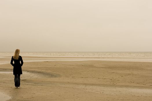 A lonely girl standing at the seashore