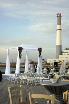 Chuppah with industrial view at the sea beach