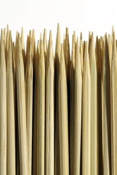 Sharpened bamboo skewers against white background