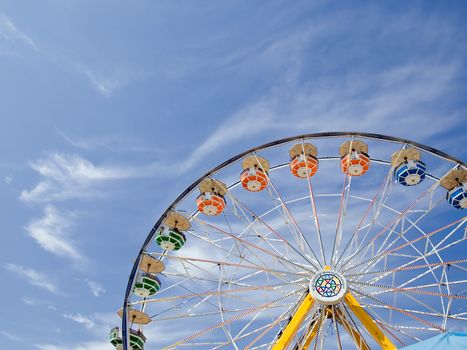 The top of a ferris wheel on the blue summer sky.