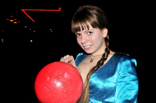  	young beautiful girl is holding red bowling ball