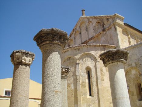 roman columns in fron of the 11th-century, three-naved Basilica of San Gavino, which was built using only precious hardstones like marble, porphyry and granite, is the largest Romanesque church in Sardinia.