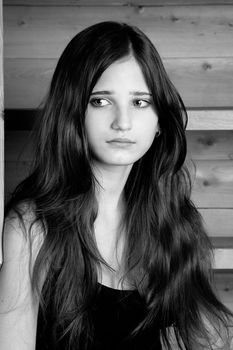 The young girl - the teenager sits on a wooden ladder 
