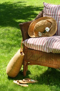 Grass lawn with a wicker chair waiting for someone to relax on a hot summer's day