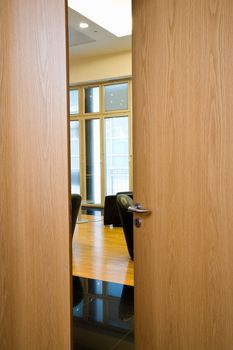 Slightly opened wooden door with the metal handle close up 
