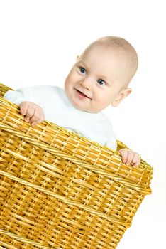 cute happy six months old  baby boy sitting in the basket 