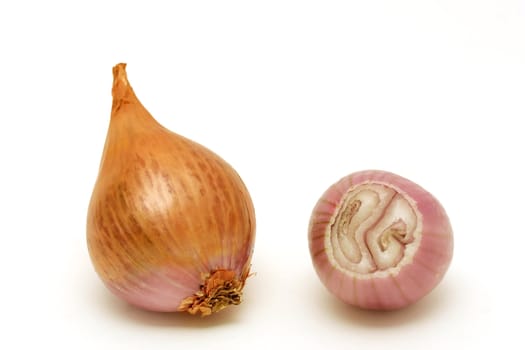 Two shallots close-up. One is peeled and cut, showing its texture.