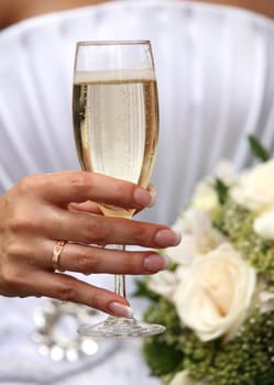 Glass of champagne in a hand of the bride