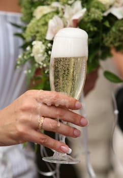 Glass of champagne in a hand of the bride