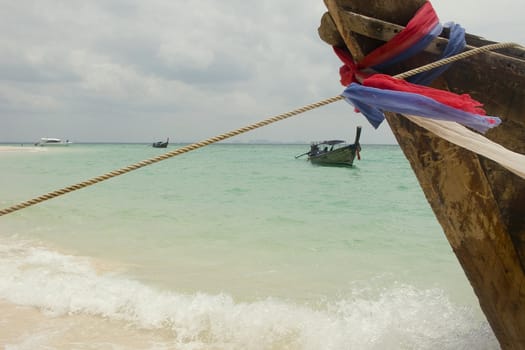 Detail of a "longtail" boat on the beach of Ao Railay, Krabi. Fabric with colors of the Thai flag hangs at the stern to bring luck to the boat.